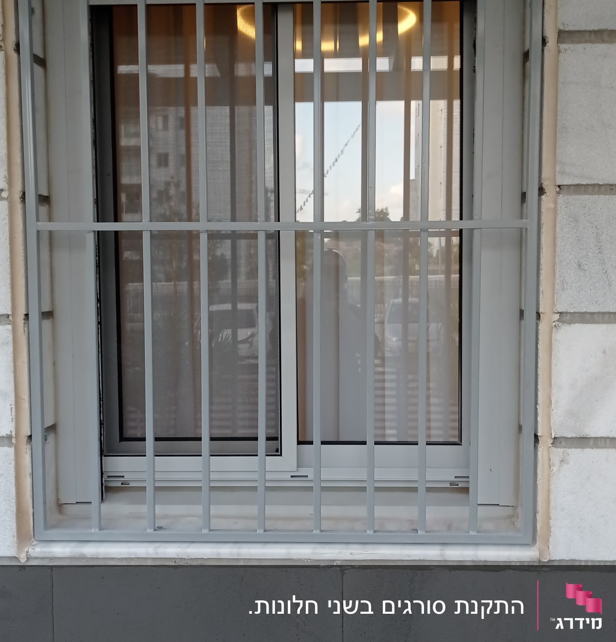 חלון עם סורגים מתכתיים על קיר אבן